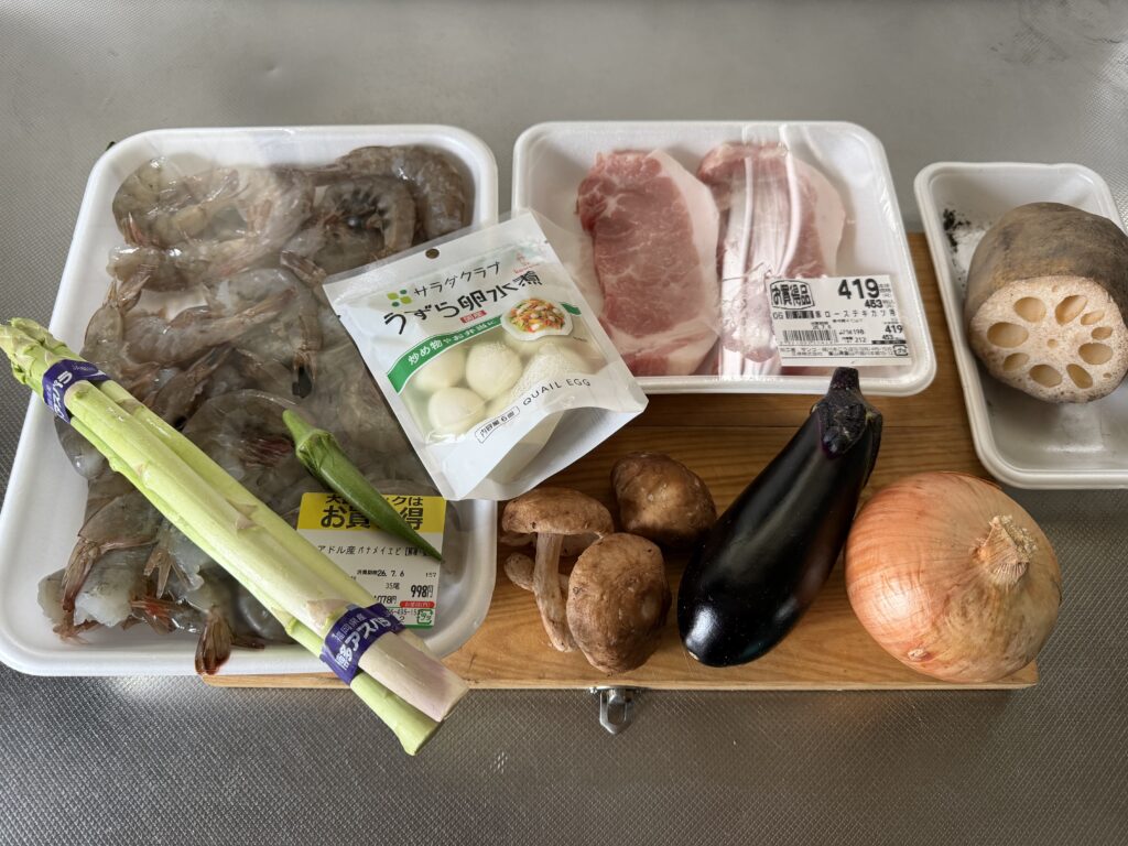 エビ、豚肉、うずら卵、アスパラ、しいたけ、ナス、オクラ、れんこん、玉ねぎを並べた様子