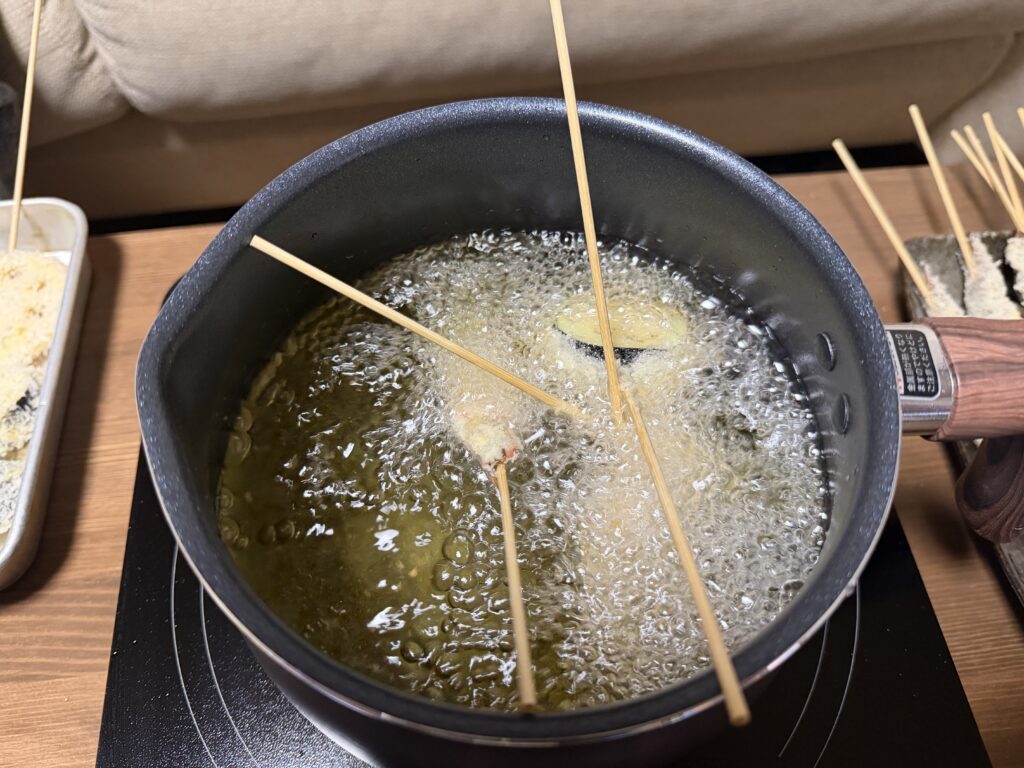 マルチポットの油で複数本の串揚げを揚げている様子