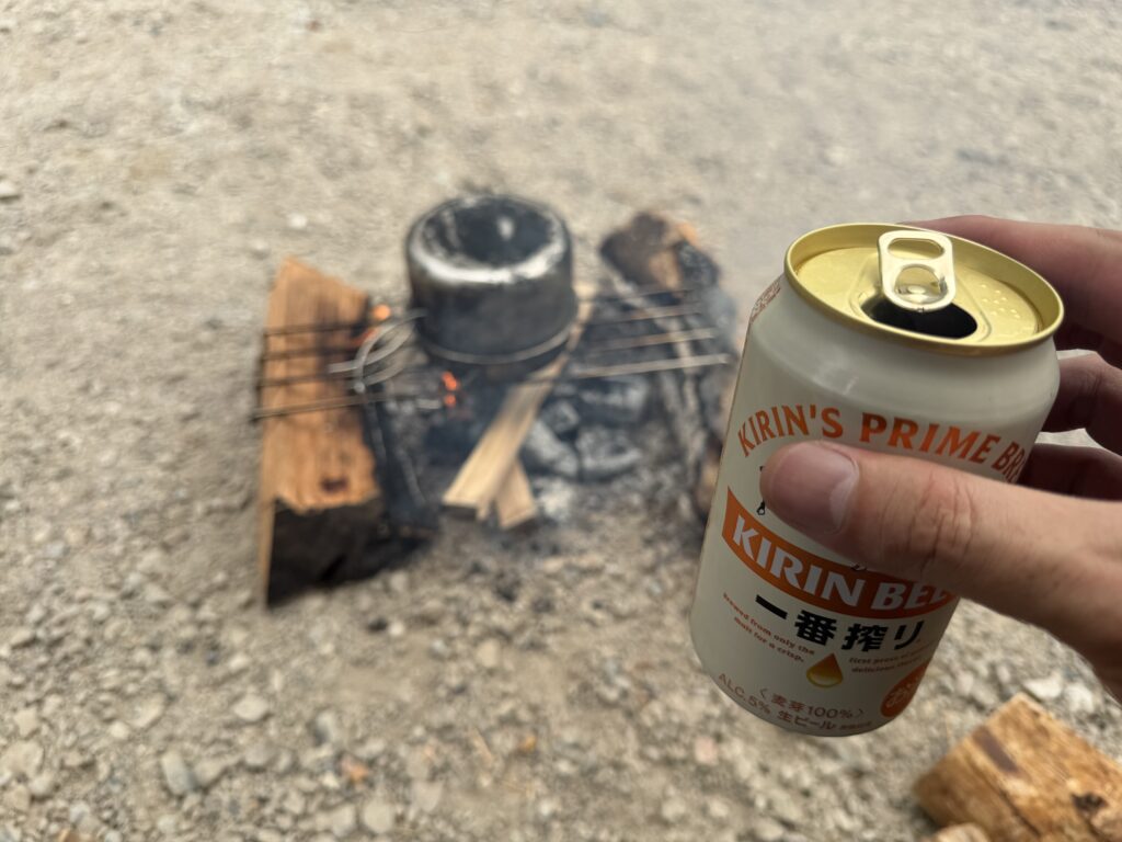 クッカーでジャガイモを蒸しながら缶ビールを飲んで待つ様子