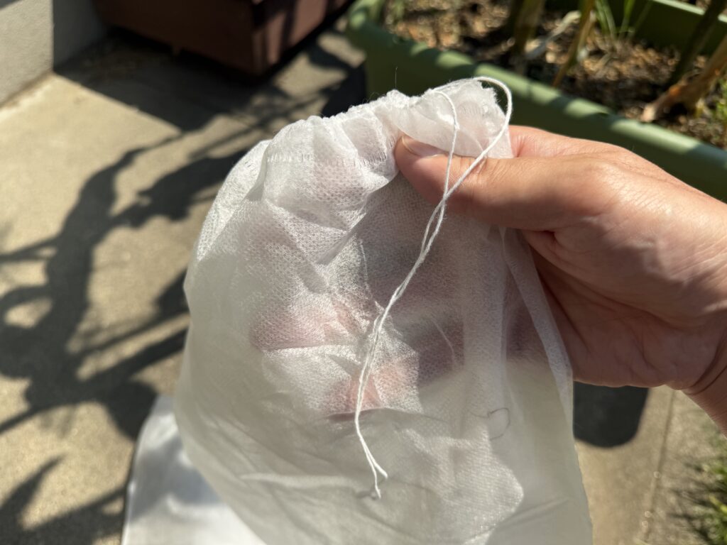 収穫後に取り外し、破れや紐の傷みを確認しているとうもろこし害虫ガード