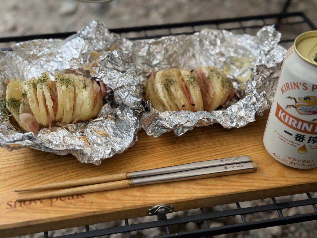 ベーコン、チーズ、バターを使い、乾燥パセリを振りかけた2個のハッセルバックポテト