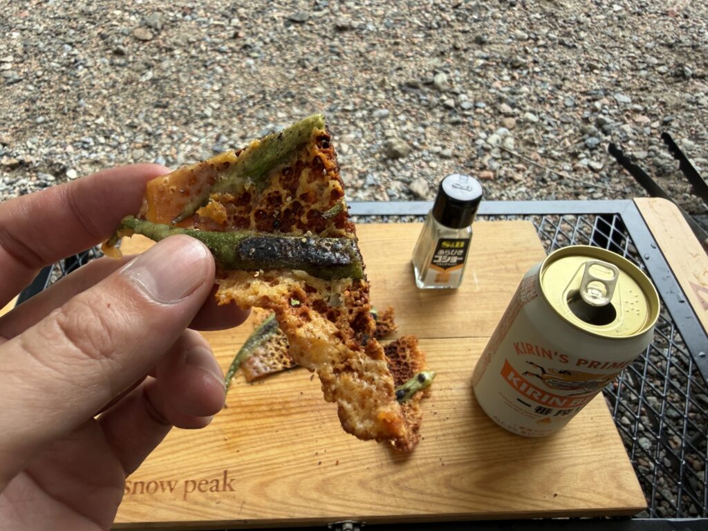 チーズをカリカリに焼いたオクラを手で持ち上げた様子