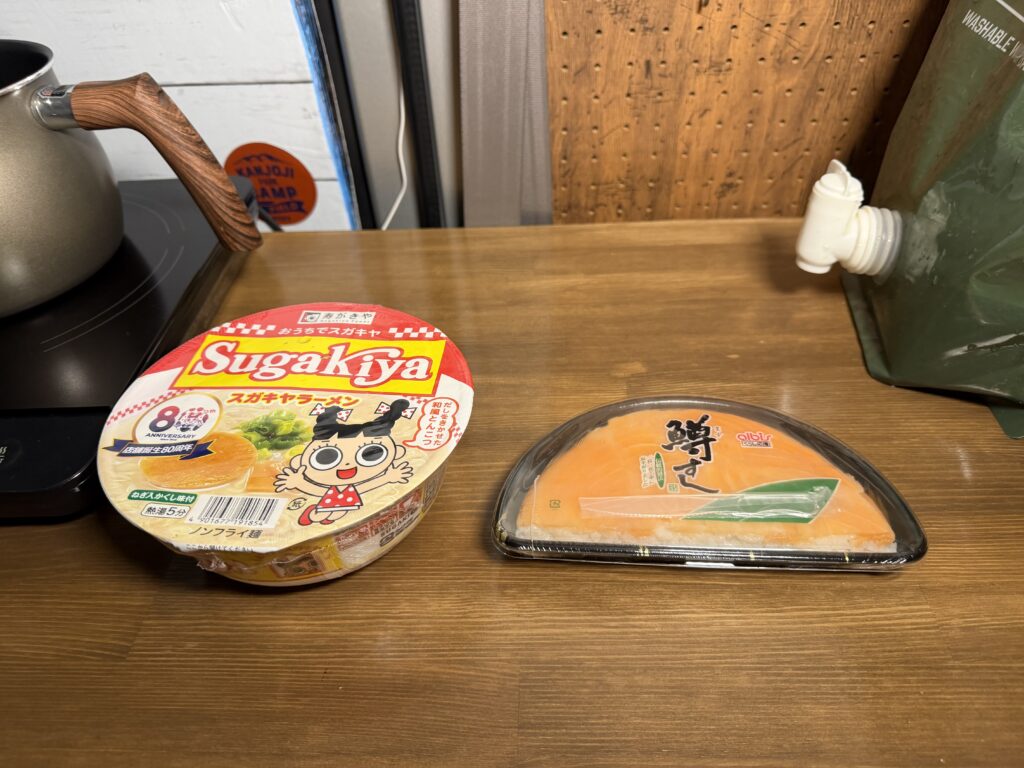 エブリイの車内に並べた、昼に食べそびれたます寿司と締めに食べるスガキヤのカップ麺
