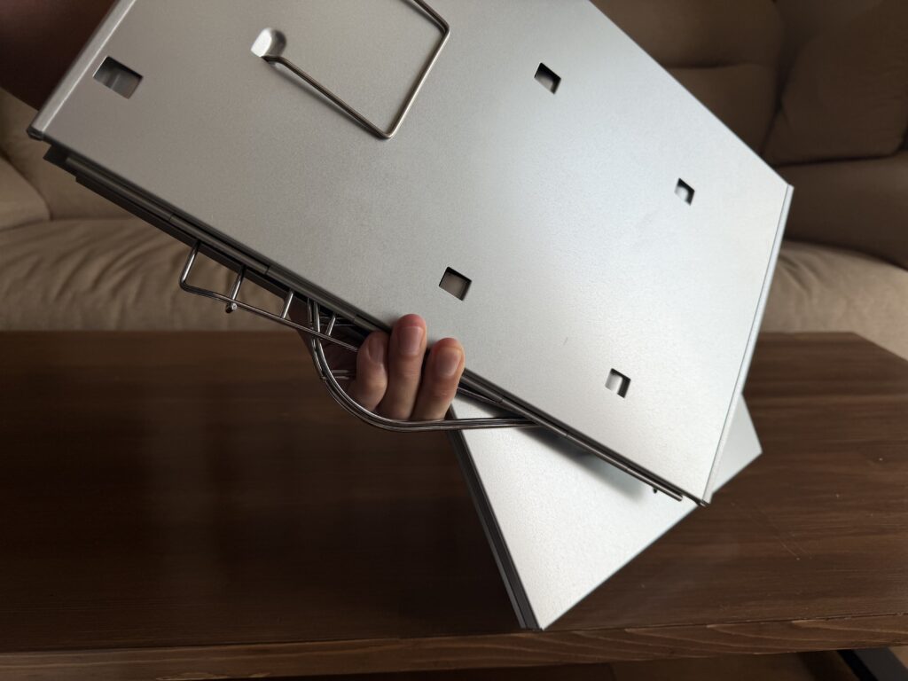 折りたたんだM-6547から網などの付属品が落ちそうになっている様子