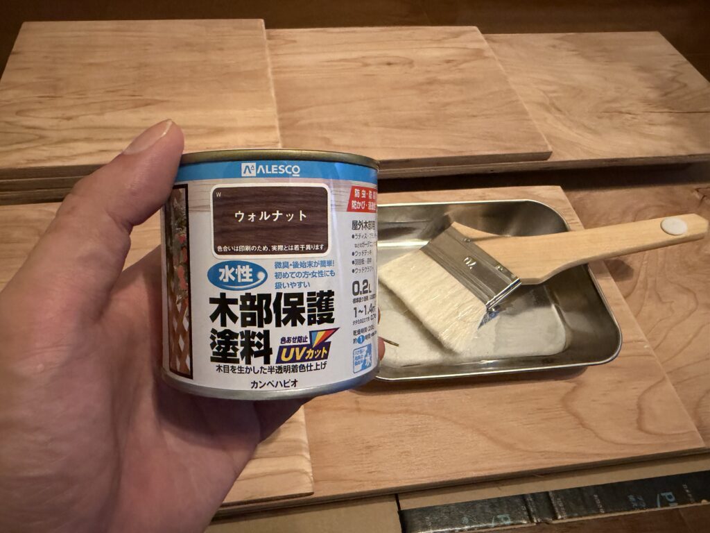 玄関で自作レベラーを塗装するため木部保護塗料と刷毛を準備した様子