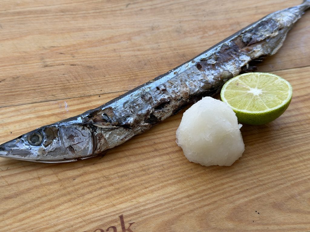 炭火で焼いたサンマに大根おろしとすだちを添えた一皿