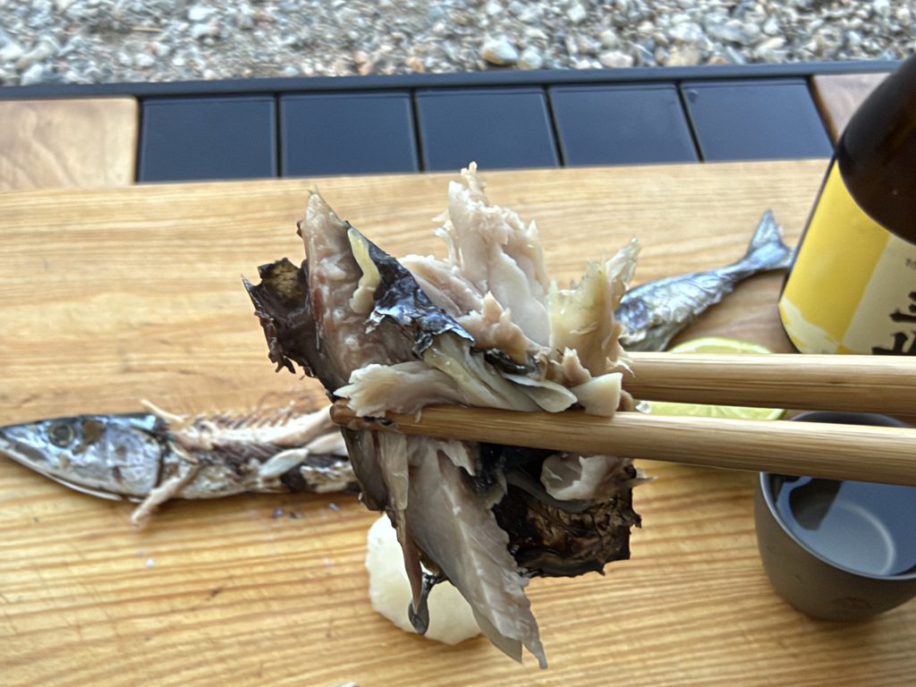 炭火焼きにしたサンマの身を箸で持ち上げた様子