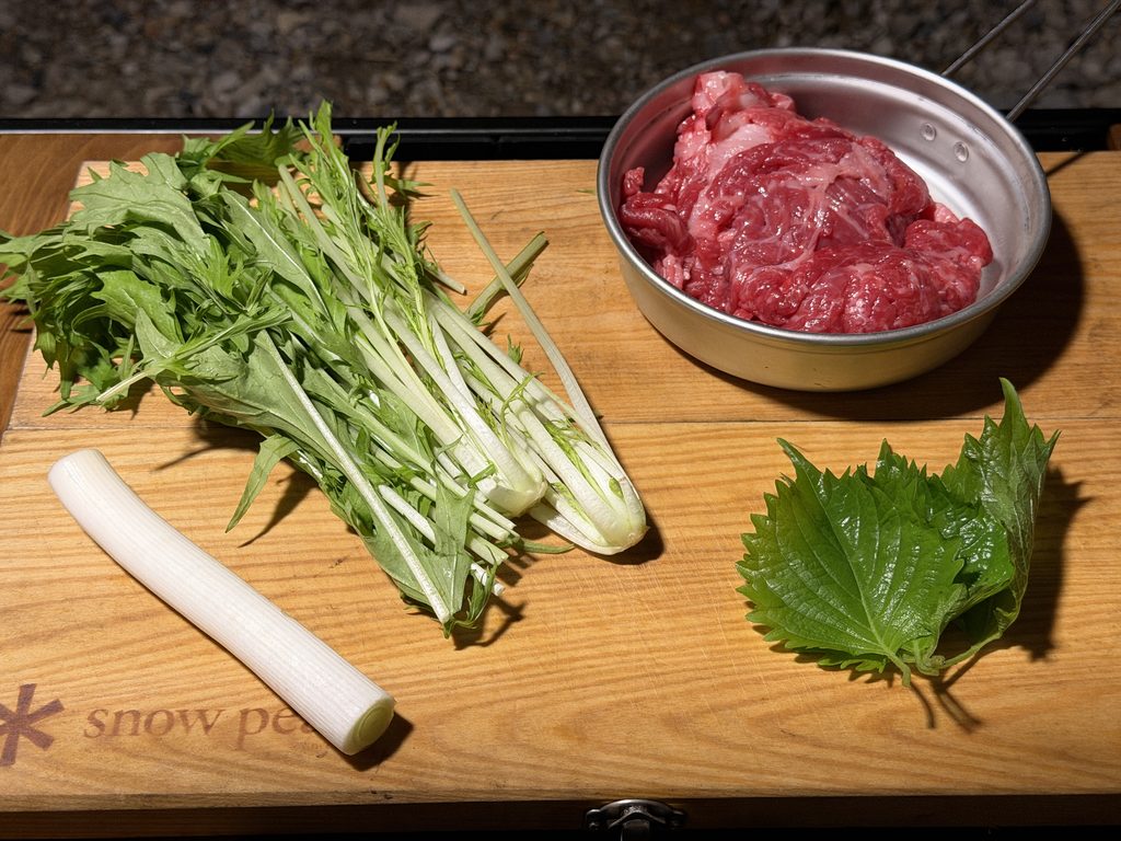 焼きしゃぶ用の博多和牛の切り落としと水菜、長ネギ、大葉を並べた様子
