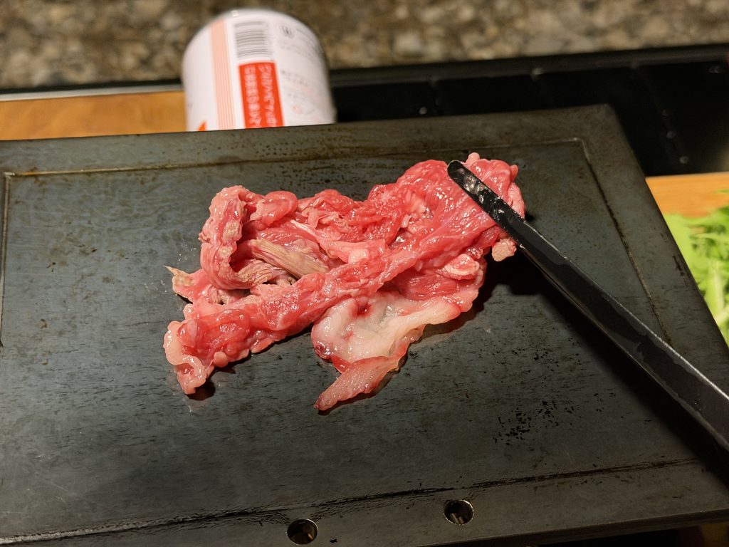 熱した鉄板に博多和牛の切り落としを広げて焼く様子